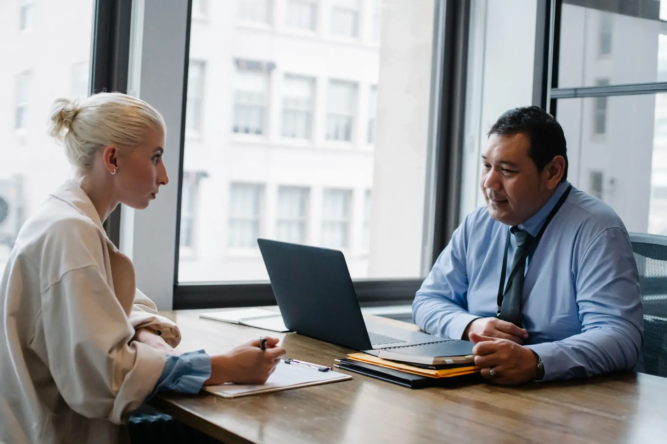 A job candidate in an interview with a hiring manager at an office desk